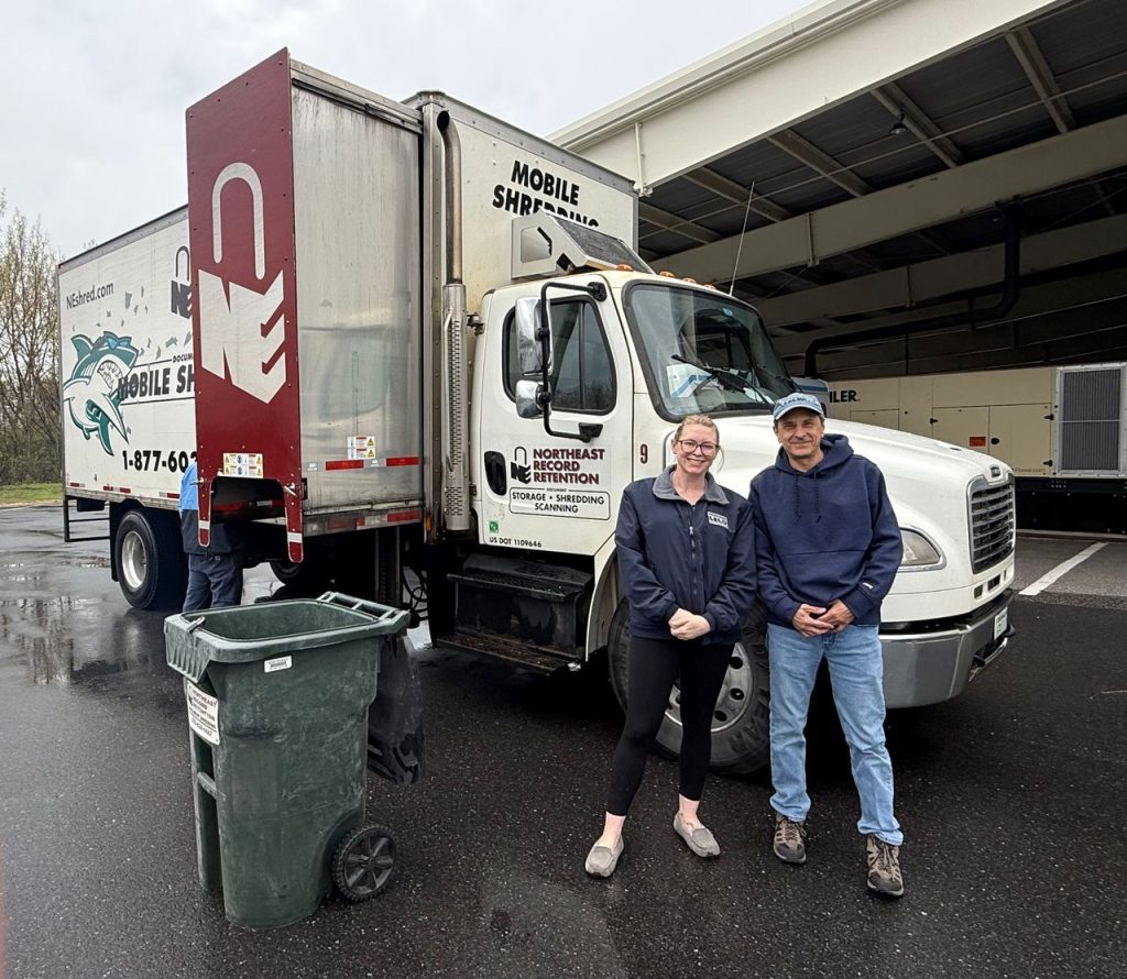Photo of Sara and Ivan in front of the community shred event truck